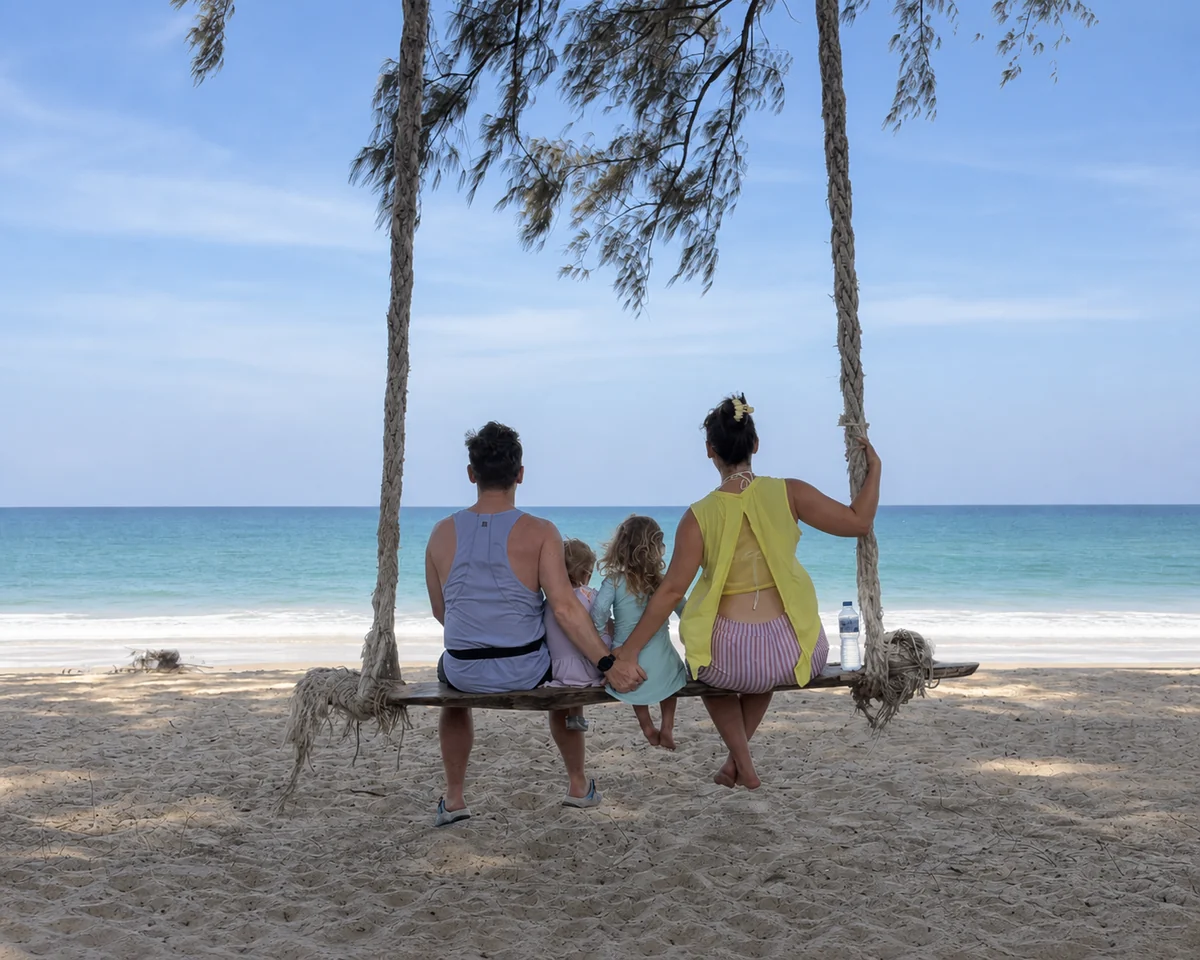 A family sitting on a beach swing and looking at the sea
